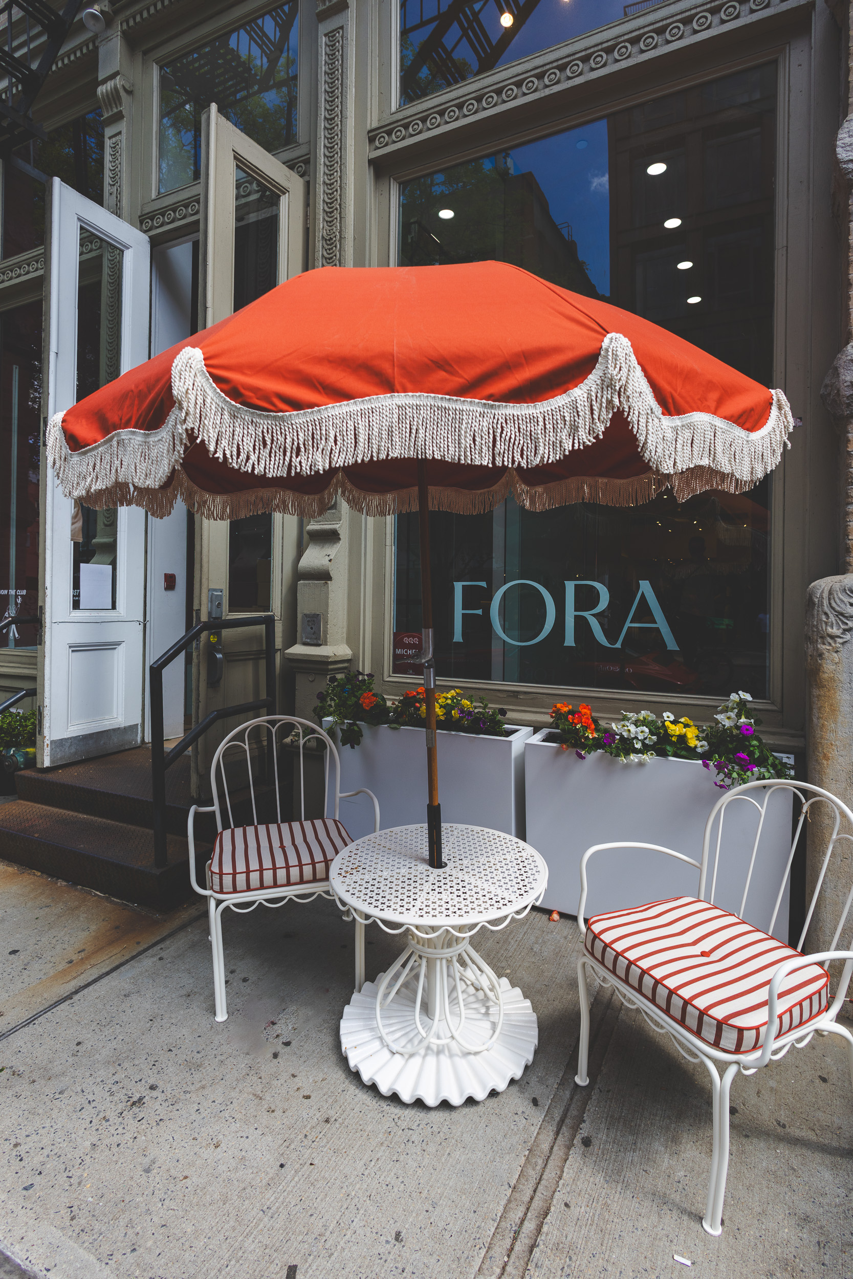 Fora exterior — red umbrella, bistro chairs