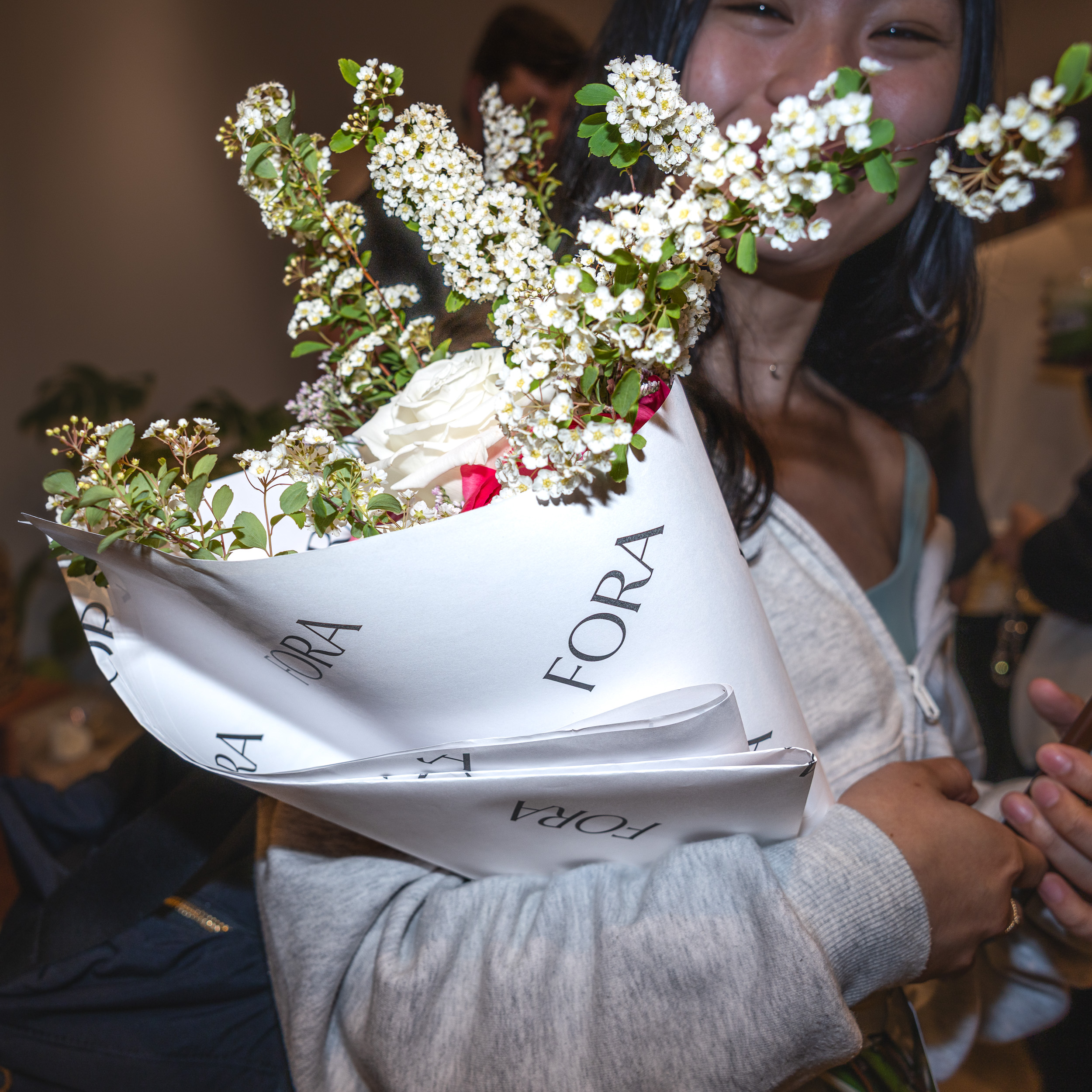 Woman holding Fora-wrapped bouquet