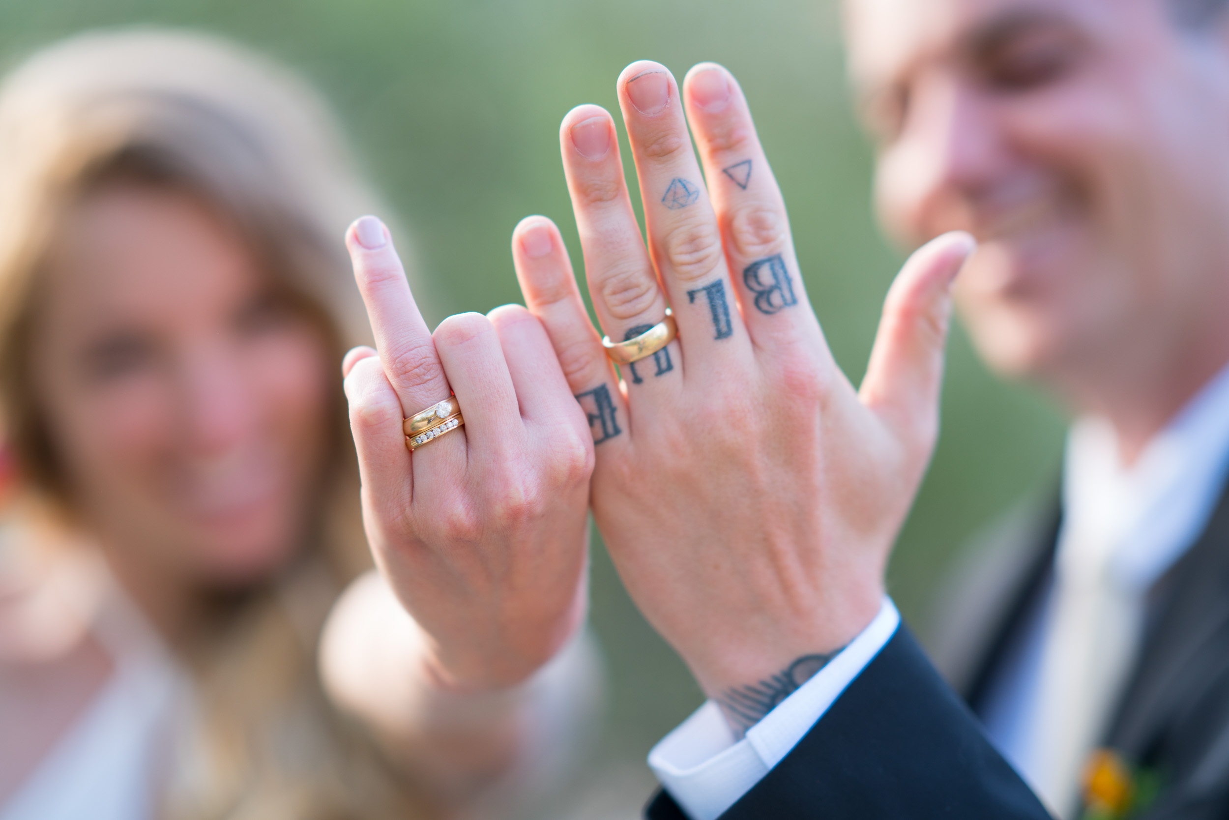 Rings on tattooed hands, close detail