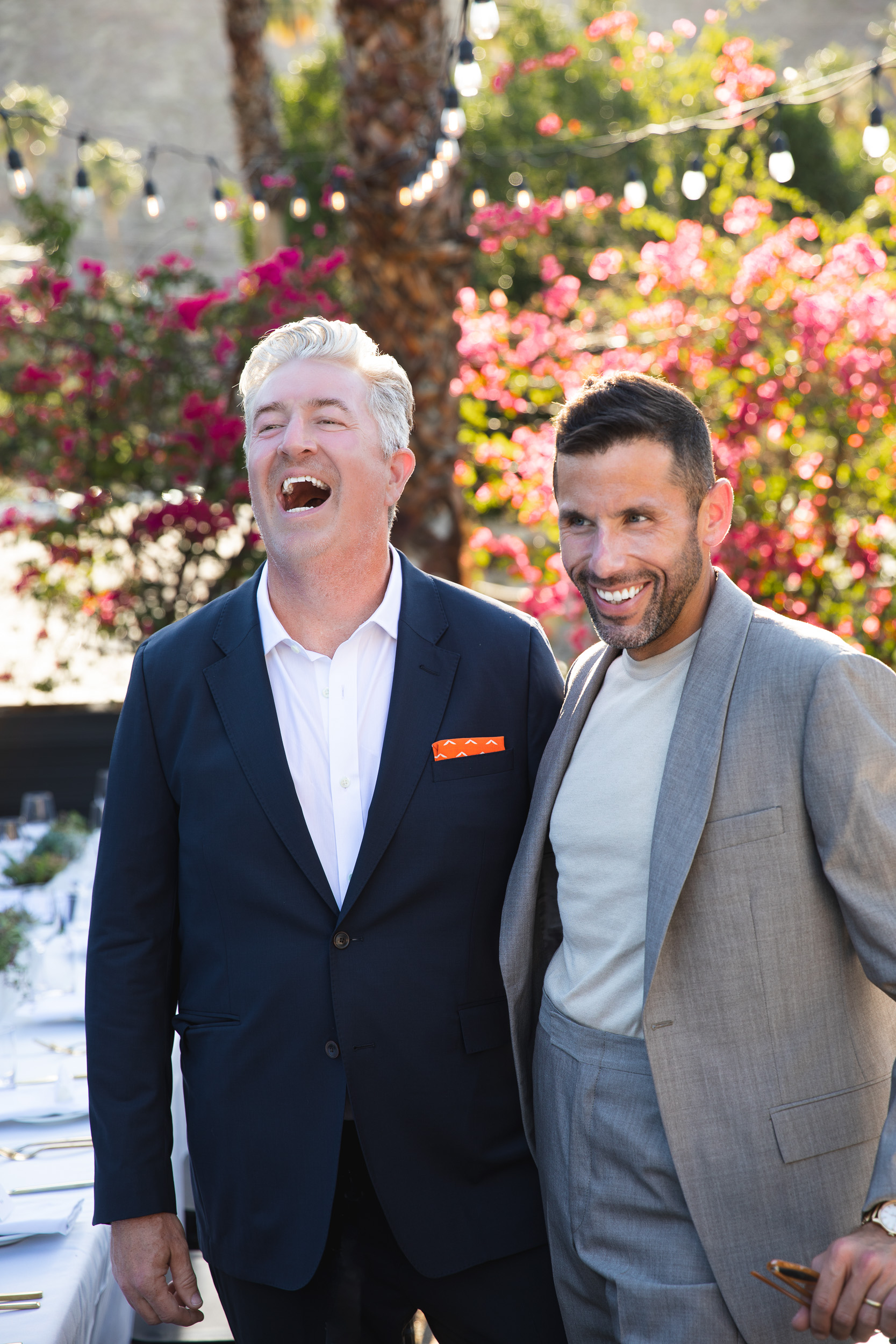 Couple laughing together in front of bougainvillea