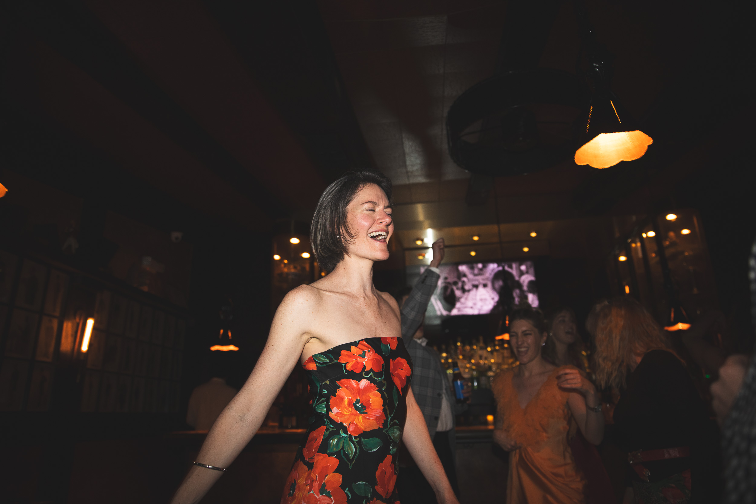 Woman in floral dress dancing alone, warm glow