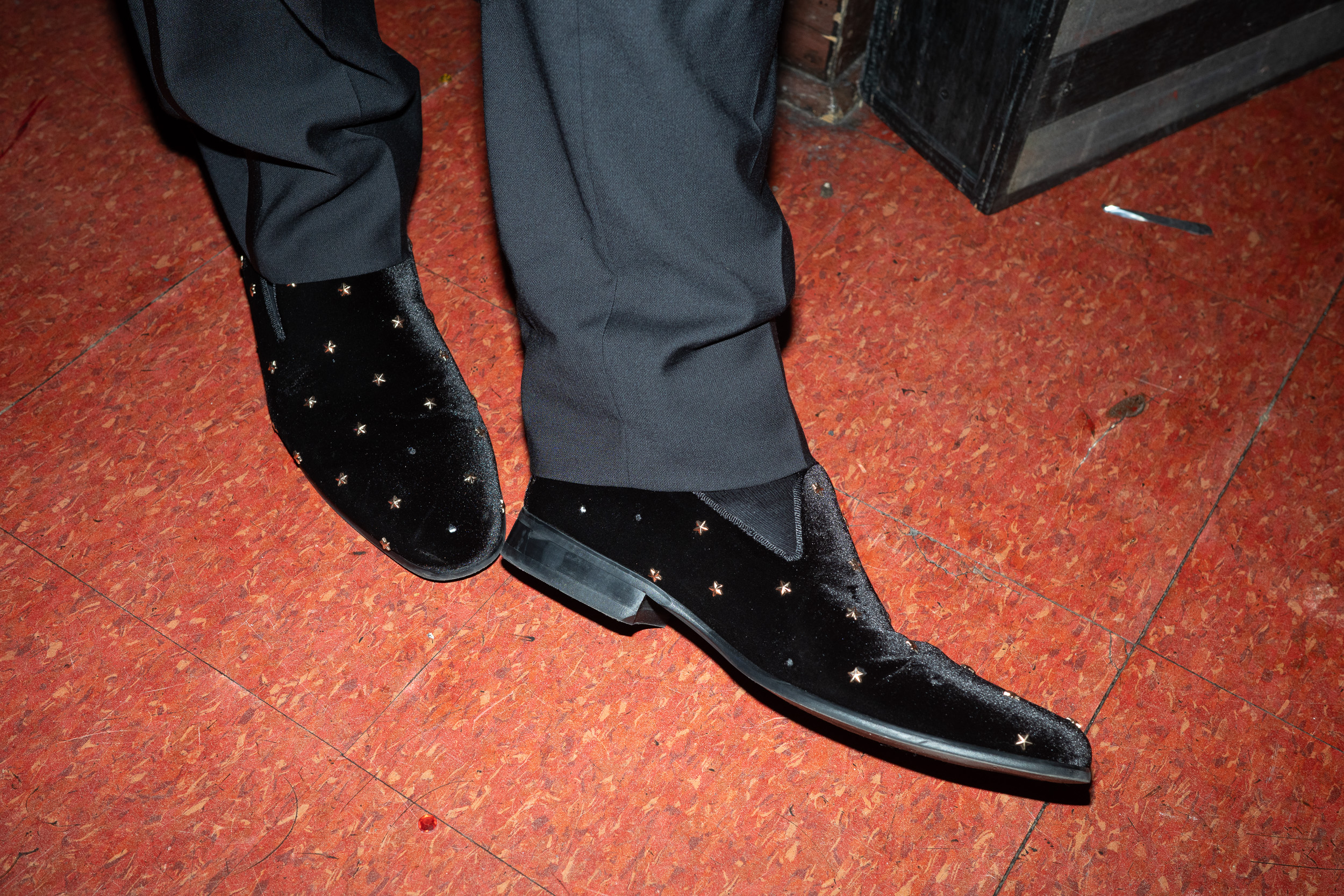 Star-studded dress shoes detail on patterned carpet